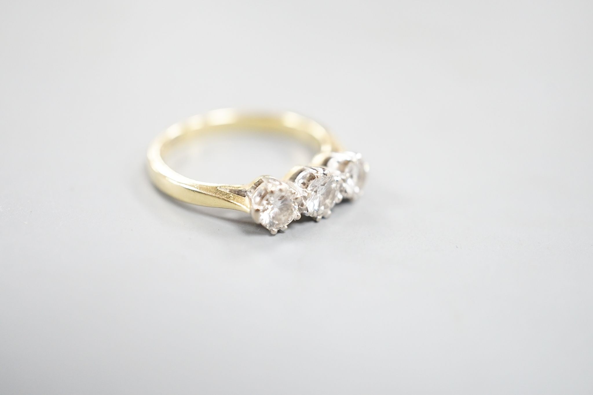A modern 18ct gold and three stone diamond set ring, size J, gross weight 3 grams.